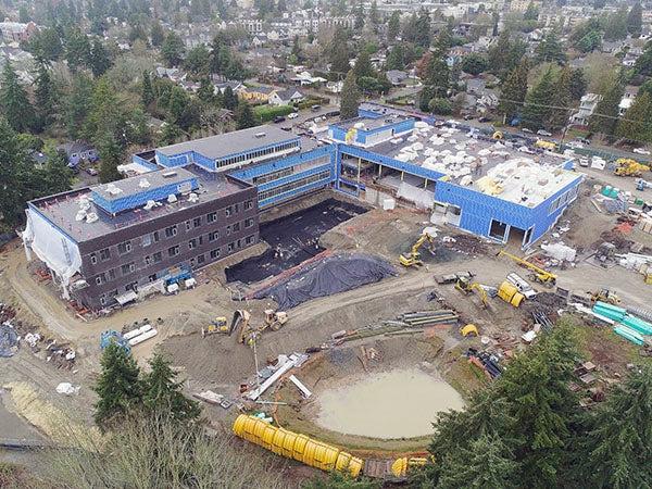 aerial showning a large L shaped building and construction site