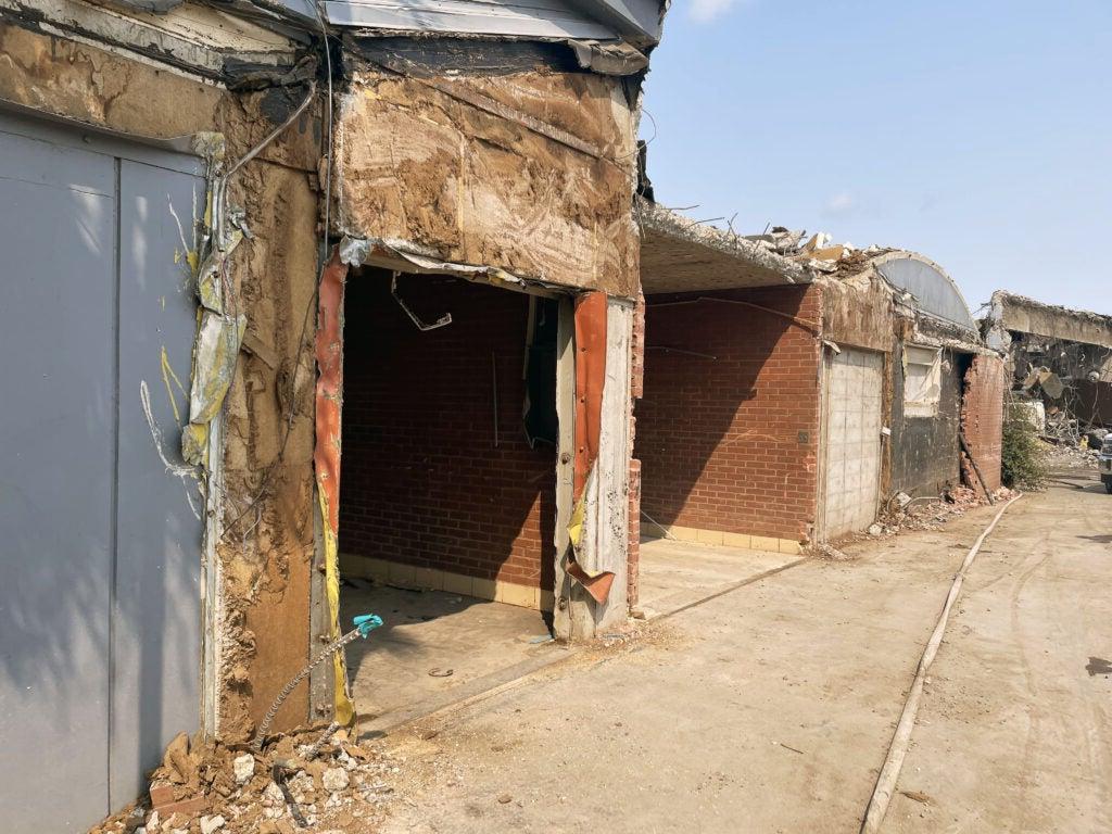 a partially demolished building that is part brick. the brick part remains